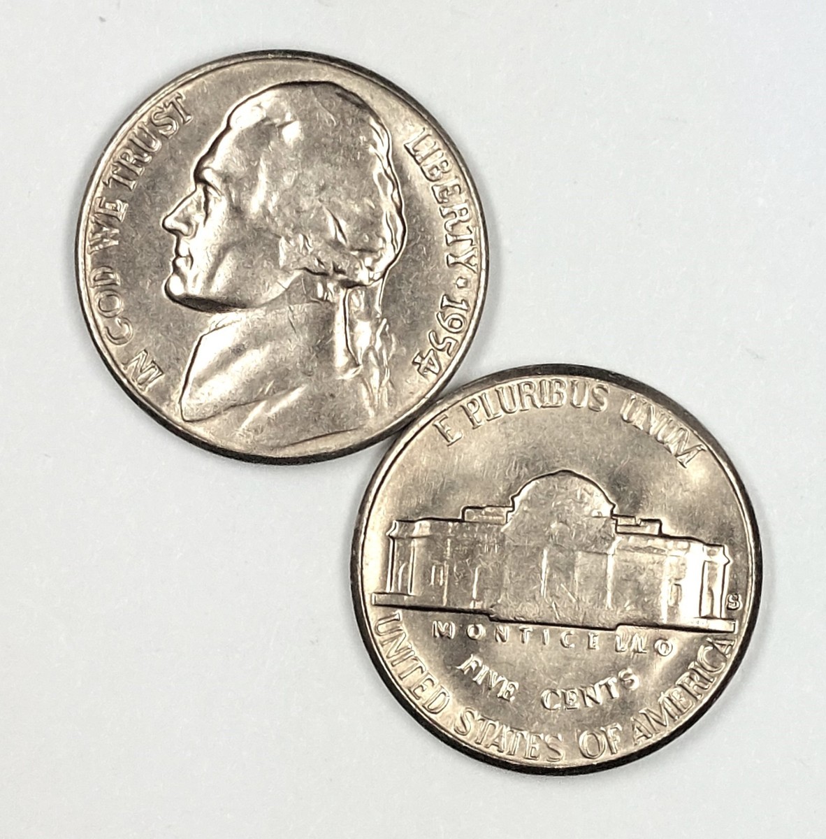 1954 Jefferson Nickel grading strip showing four coins from worn Good grade through Mint State uncirculated condition